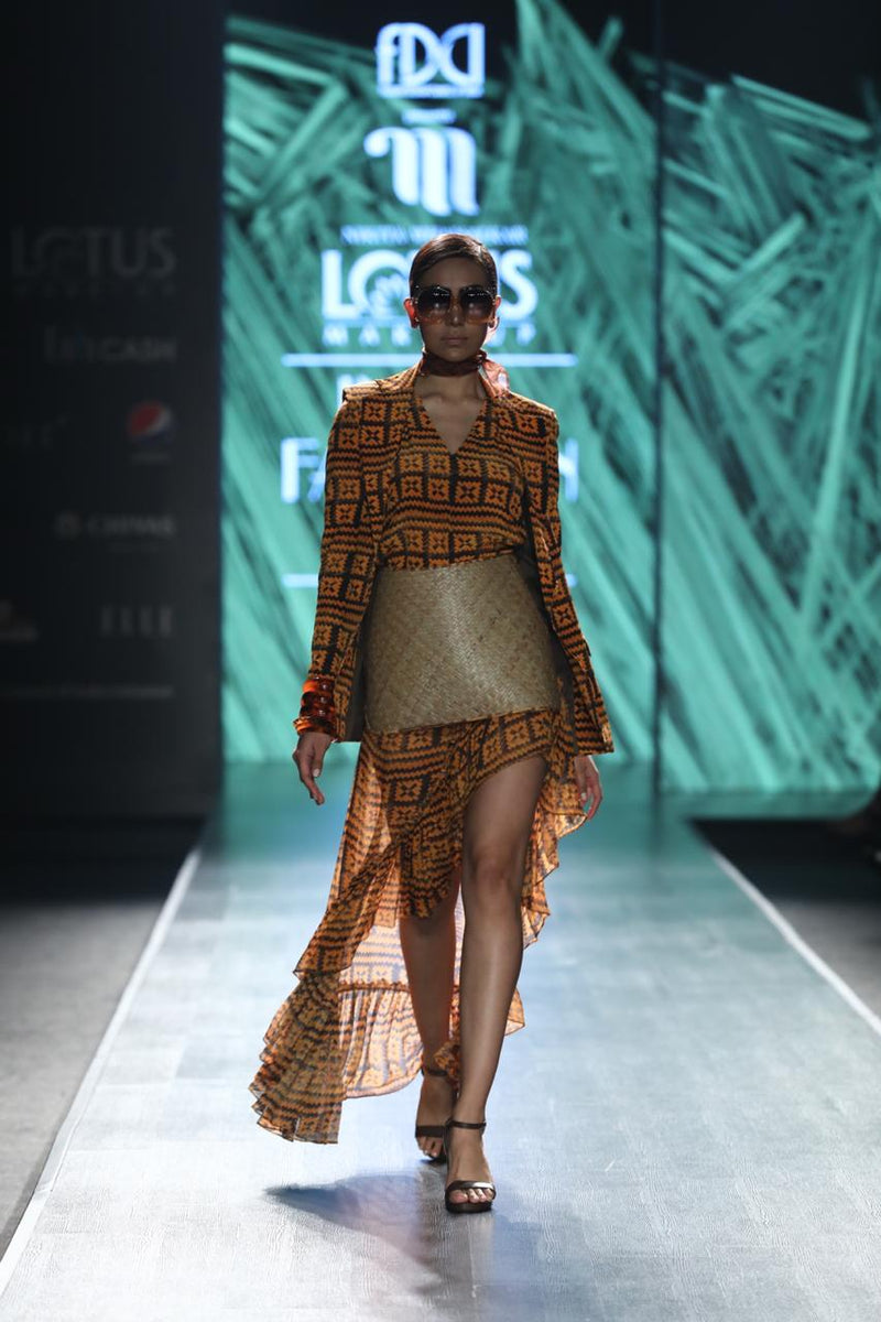 Winnie Harlow In Orange-Brown Basket Weave Print Ruffled Skirt With Side Slit